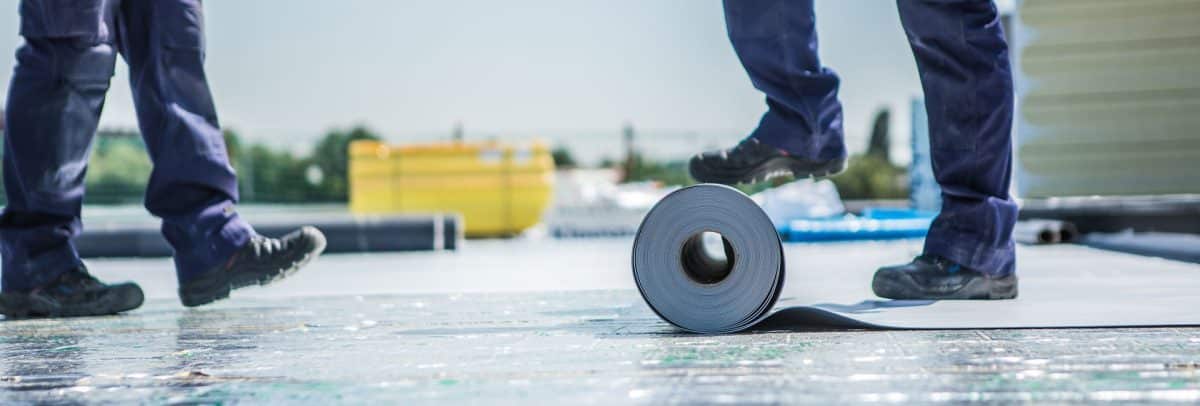 bitumen dampscherm worden uitgerold op plat dak